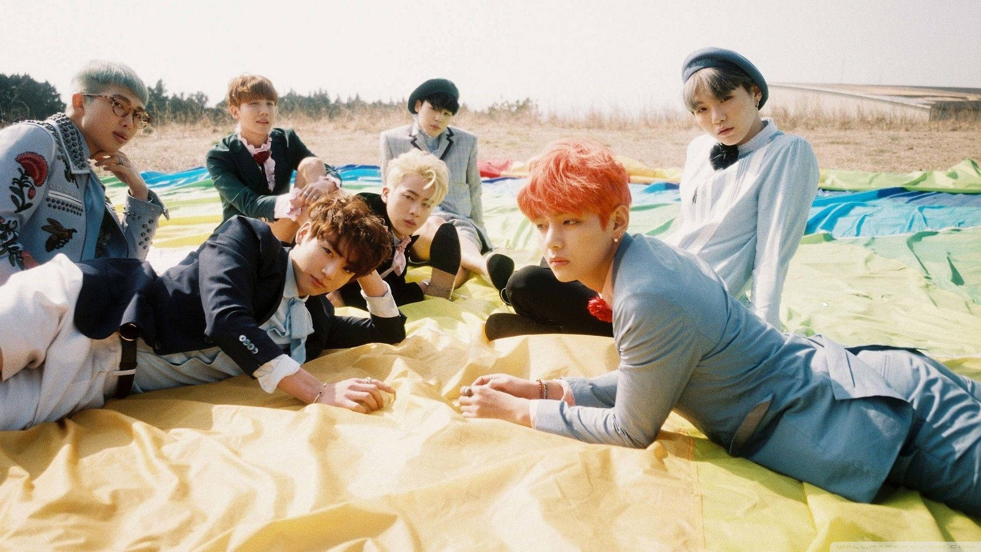 اعضای گروه BTS روی زمین با لپ‌تاپ والپیپر