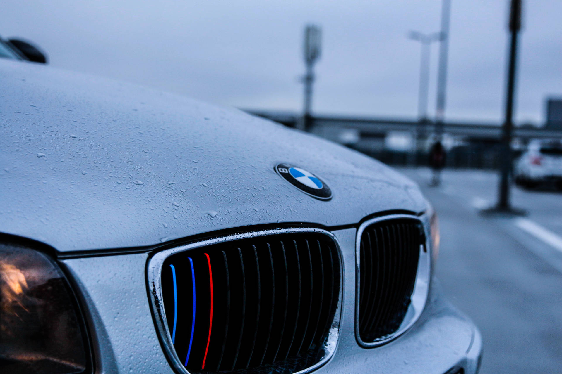 والپیپر نمای نزدیک از کاپوت سفید خودروی BMW با قطرات باران — بی‌ام‌و والپیپر