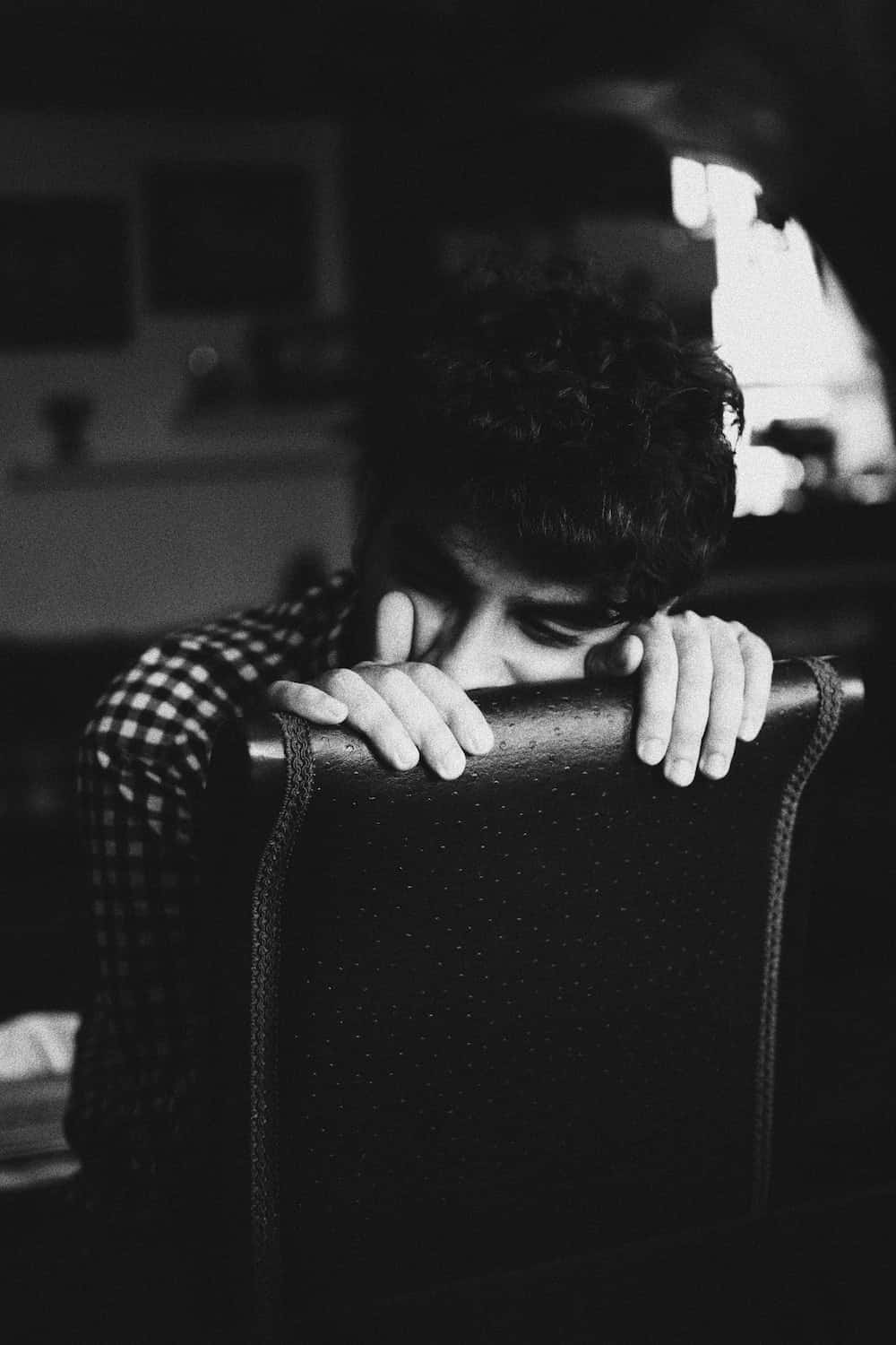 مردی روی صندلی نشسته و دستش را روی صورتش گذاشته است والپیپر