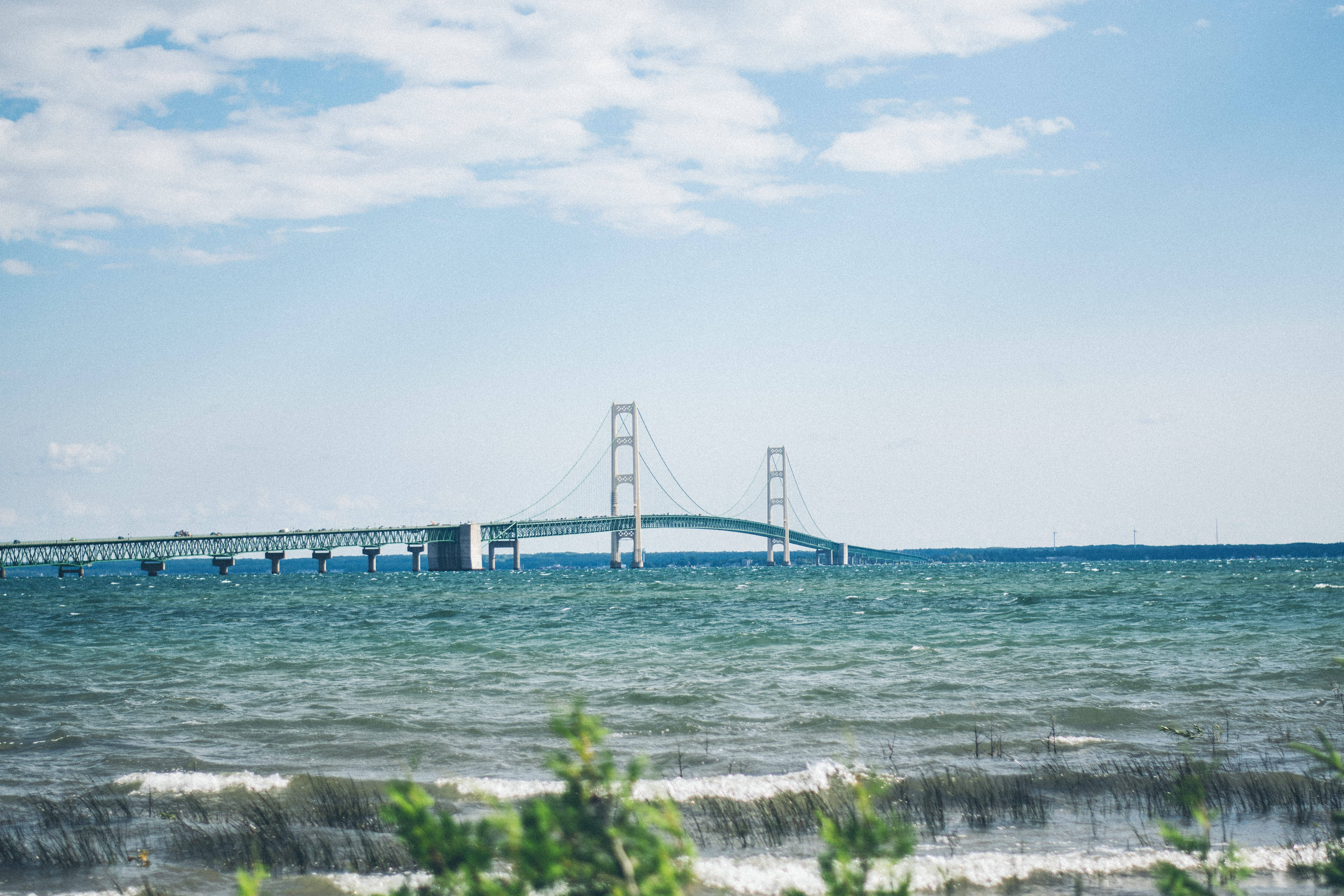 پل باشکوه مکینک که بر روی آب‌های آرام آبی کشیده شده است والپیپر
