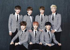لپ‌تاپ باحال BTS با کت و شلوار چهارخانه خاکستری